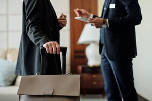 Hoteldirektor spricht mit einem Gast und hält dabei ein Tablet in der Hand.