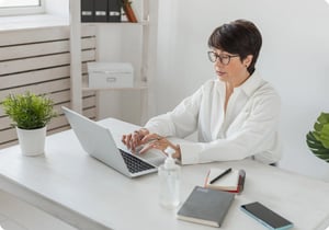 De HR-manager van een supermarkt werkt de personeelsgegevens bij in de supermarkt software op haar laptop.